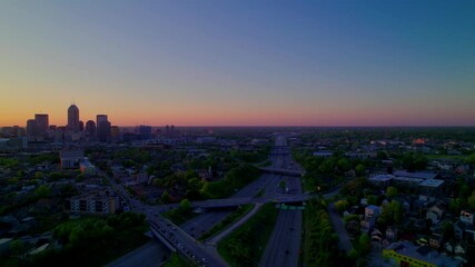 Wall Mural - Stunning aerial footage of Indianapolis skyline during sunset, featuring busy highways and urban neighborhoods.