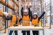 © Koldo_Studio - Warehouse workers and their manager are celebrating a successful operation by raising their arms in a large distribution center