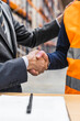 © Koldo_Studio - Manager and warehouse worker shaking hands after finalizing a contract in a logistics center, celebrating a successful business partnership