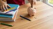 © Dery - school supplies and piggy bank on desk family remittance education investment future