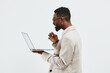 © SHOTPRIME STUDIO - Professional young African-American man in smart casual attire holding a laptop, looking at the screen with focus isolated on plain white background. Business, technology, work, education, modern