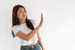 © Suthida - Asian woman holding up hand in rejection gesture, isolated over white wall.