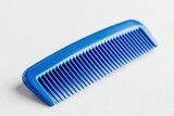 Straight blue plastic comb with even teeth placed on a light background for styling hair