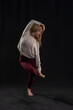 © dfriend150 - a person performing a yoga pose, balancing on one foot while holding the other with an opposite hand. They are dressed in a light-colored sweater and maroon leggings