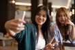 © Ranta Images - two female friends sitting in a cafe taking selfie with phone