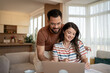© Migma_Agency - Happy couple managing domestic finances with laptop at home