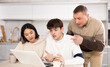 © JackF - Friendly family watches something together on the Internet or video chats via a laptop