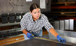© JackF - Woman apprentice measures metal sheet with tape measure