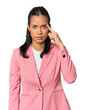 © Asier - Young Filipina in pink suit pointing temple with finger, thinking, focused on a task.