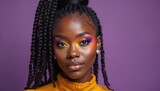 Confident black woman with stylish two tone braids and colorful makeup. Young female has a radiant smile on purple background. Eye makeup, fashion portrait studio look.
