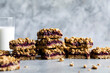 © The Picture Pantry - A stack of oatmeal berry crumble bars is displayed on a table alongside a glass of milk.
