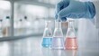 © pingpao - Scientist wearing blue gloves uses a pipette to add liquid into a conical flask with pink solution in a laboratory setting.