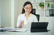 © matinee - Smiling businesswoman checking financial performance reports in bright office.