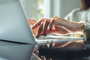 Wall Mural - close up, business woman hand typing on laptop computer keyboard with sunlight. woman online working