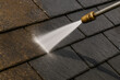 © smth.design - High pressure water cleaning dirt and grime from dark roof shingles, restoring surface with powerful jet stream for maintenance