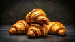 © kavalin - Golden-brown croissants, freshly baked and stacked high, a tempting treat for breakfast or a delightful snack