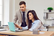© Studio Romantic - Business people, corporate mentor showing new employee company data at laptop, training intern, male, female coworkers watching presentation, reading message, working together at desk computer