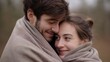 © Evgenia - Young couple wrapped in cozy blankets, sharing a warm embrace outdoors, radiating love and affection in a serene natural setting, capturing intimate emotional connection