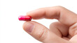 © noz-studio - Close up of a hand holding a small red and pink capsule against a white background in studio shot
