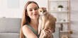 © Pixel-Shot - Young woman with cute kitten sitting on yoga mat at home