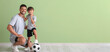 © Pixel-Shot - Little boy with soccer ball and trainer near green wall
