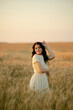 © sergo321 - A young brunette walks in wheat fields at sunset in summer. Growing organic wheat and barley.