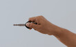 © PRIYO DWI SAPUTRO - Hand holding a motorcycle or house key isolated over a white background.