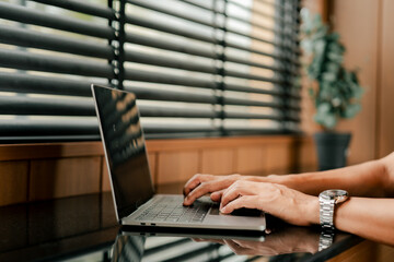 close-up of typing on laptop computer keyboard. working online in office.