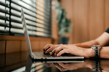 close-up of typing on laptop computer keyboard. working online in office.