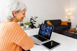 © Xavier Lorenzo - Smiling senior woman working on laptop having a video conference with her team, working remotely from home. Senior adult person studying online. E-learning concept.