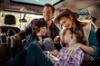 © Davor - Happy family sitting in car taking pictures during road trip