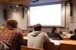 © Andrey - Students observe a blank projector screen during a lecture in a university auditorium filled with anticipation for the lesson
