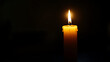 © Bhait - A single lit candle casting a warm glow in the darkness