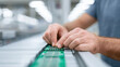 © nddcenter - Closeup of hands assembling green circuit board in modern factory, focusing on precision and technology in electronics manufacturing process