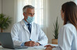 © miss irine - Doctor consults female patient wearing face mask. Physician writes notes, fills medical chart during appointment at clinic. Healthcare, disease prevention during pandemic, virus spread.
