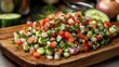 © Hamba - Freshly chopped salad of diced vegetables on a wooden board