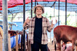 © Gatot - Asian Cattleman Showing Cellphone and Giving Thumbs Up. Modern Technology of Agriculture Cattle.