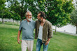 © Halfpoint - Senior dad and middle-aged son enjoying peaceful walk in park.