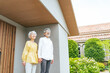 © metamorworks - 笑顔で住宅の前に立つシニアカップル