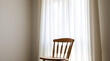 © Abdulloh - Wooden chair standing by window with white curtains letting in natural light