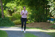 © Songsak C - A woman in sportswear running in the park, enjoying fresh air, engaging in outdoor activities to maintain a healthy lifestyle, boosting cardiovascular health, and feeling happy and energetic.
