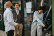 © qunica.com - Colleagues enjoy a relaxed conversation during a business meeting in front of a stylish co working cafe, reflecting collegiality, casual networking, and shared interests in a professional setting.