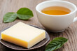 © pavlofox - Cheese and tea pairing on wooden table with fresh leaves