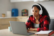 © PheelingsMedia - Serious black student with headphone checking personal computer