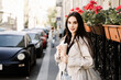 © Denira - Young woman walking with coffee cup on city street in spring