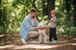 © standret - Sitting, playing with pet. Father with son and dog are in the forest