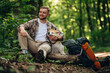 © standret - Break time, sitting. Man tourist is with his dog in the forest