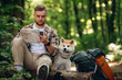© standret - On a log, sitting. Man tourist is with his dog in the forest