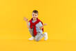 © New Africa - Happy little boy dancing on orange background