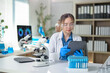 © Wasana - A woman in a lab coat is looking at a tablet computer